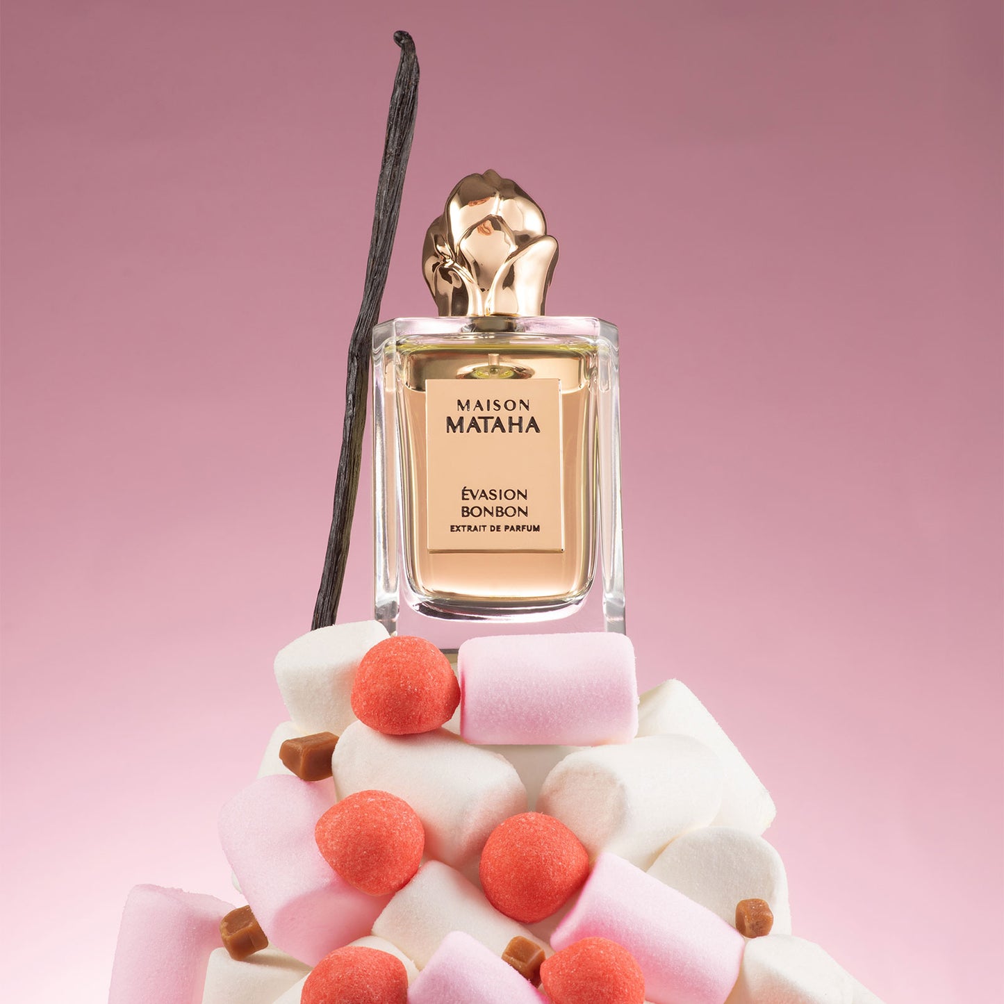 Flacon de parfum en verre evasion bonbon en extrait de parfum avec un fond rose et des bonbon